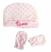 Accessoires de naissance coordonnés comprenant un bonnet rose en minky et une paire de moufles assorties.