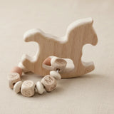 "Anneau dentition personnalisé composé de perles en silicone colorées et de bois naturel, orné d'un charmant motif de cheval à bascule pour l'éveil de bébé.