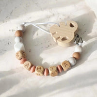 Attache tetine MAM en bois et perle silicone marbré pour bébé.