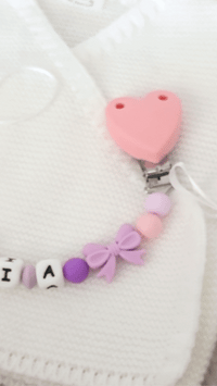 Modèle d'attache tetine fille de couleur lilas et rose 