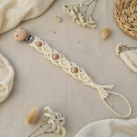 attache tetine macrame crème présenter sur une table boheme