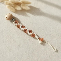 attache tetine macrame marron crème torsadé poser sur un fond boheme