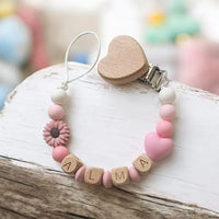 attache tétine personnalisé en silicone et bois de couleur rose et blanc