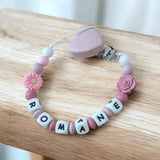 Attache tétine silicone fleurs pour bébé avec perles colorées et clip sécurisé.