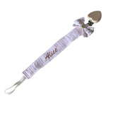 attache tetine en tissu avec son noeud floral rose et blanc
