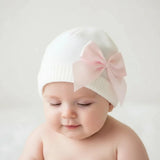 Bonnet bebe en laine blanc noeud rose  fille en laine douce couleur blanc avec nœud rose porter par un bébé