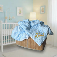  présentation d'une couverture bebe polaire de couleur bleu en minky