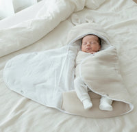 vu d'interieur avec un bebe dedans la couverture d'emmaillotage sablé