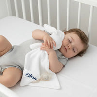 doudou attache tetine avec bébé allonger sur son lit 