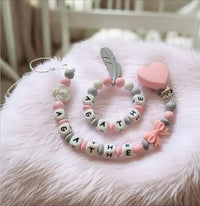 ensemble d'attache tétine et hochet assortis de couleur rose 