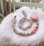 ensemble d'attache tétine et hochet assortis de couleur rose 