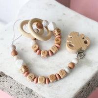 Ensemble attache tetine MAM et anneau de dentition assortis en perle bois et silicone marbré.