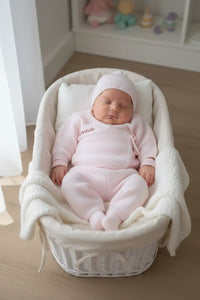 ensemble bébé naissance porter par un bébé dans un panier osier 