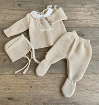 ensemble bebe en laine avec bonnet beguin poser sur une table 