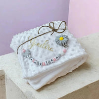 ensemble d'un plaid polaire bebe et son attache tetine silicone