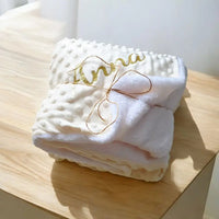 plaid bebe personnalisé prénom  en minky personnalisé au prénom de bébé poser sur une table en bois 