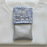 Pochette aimantée personnalisée en tissu Liberty lilas avec prénom en flocage pour bébé.