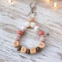 Porte-clé personnalisé prénom modèle Maya avec perles rondes en silicone et perles en bois naturel.