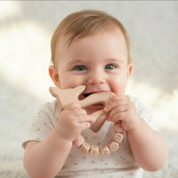 presentation d'un bébéb portant un anneau dentition en bois motif biche 