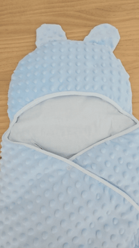 présentation d'une couverture d'emmaillotage bleu en minky 