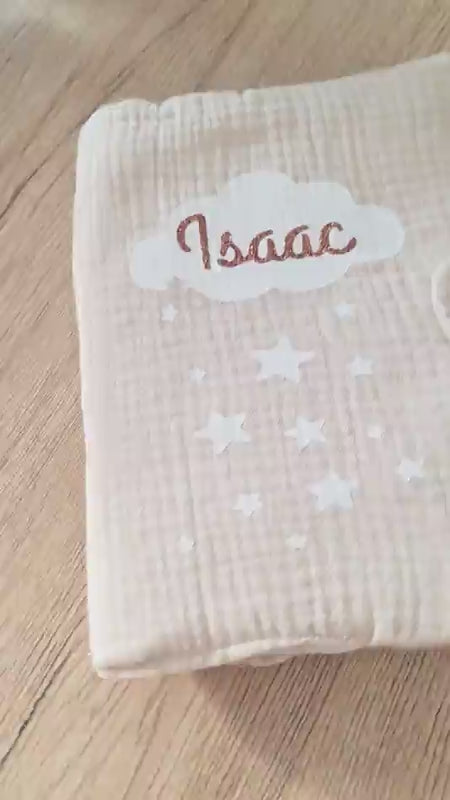 Vidéo de présentation montrant la texture gaufrée et le molletonné d'un protège carnet de santé beige personnalisé motif nuage étoilé en gaze de coton."