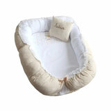 voici un reducteur de lit beige pour bébé avec son coussin avec option de personnalisation