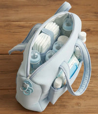 Sac à langer bleu ciel en gaze de coton accroché à une poussette pour illustrer sa praticité