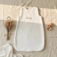 poser à plat sur une nappe une turbulette bebe blanche en gaze de coton personnalisé avec prénom de bébé