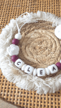 vidéo présentant attache tétine prune personnalisé pour bébé avec prénom et adaptateur mam