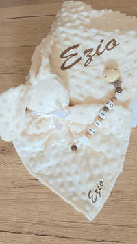 vidéo présentant un coffret cadeau naissance garçon de couleur crème et marron avec un plaid un doudou lapin et une attache tetine