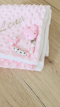 vidéo présentant un coffret cadeau naissance fille, plaid et attache tetine assortie