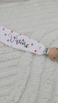 vidéo présentant une attache tétine en gaz de coton personnalisé avec petit coeur rouge 